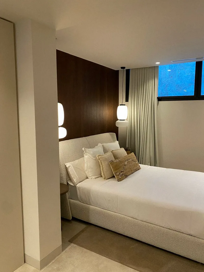 Dormitorio con panelado noble y cabecero bouclé